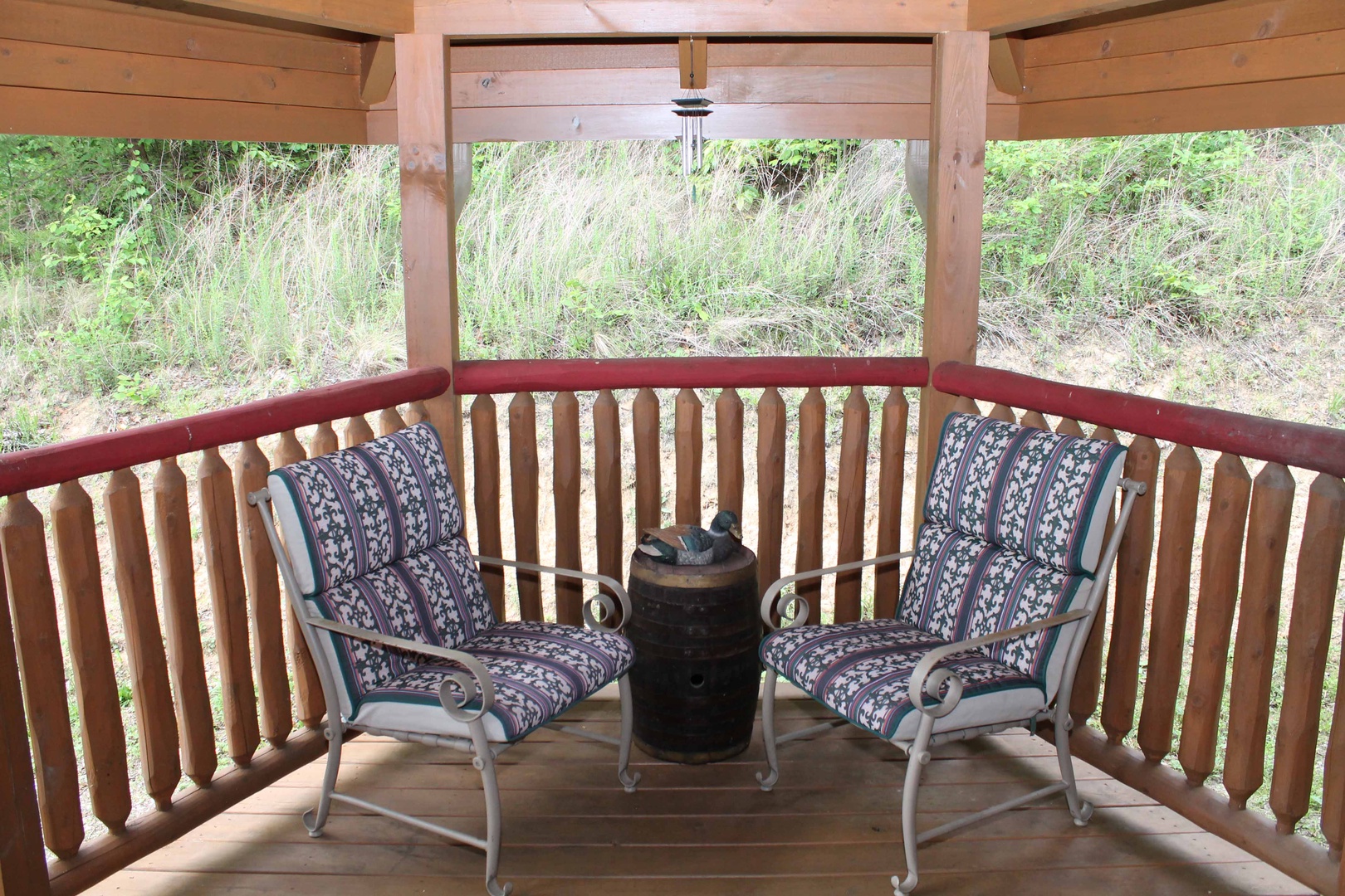 Two chairs and a small table on the covered deck at Laid Back, a 2 bedroom cabin rental located in Pigeon Forge