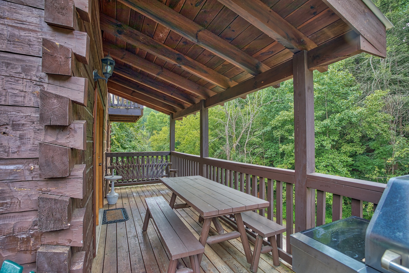 Picnic table on a covered deck at Mountain Music, a 5 bedroom cabin rental located in Pigeon Forge