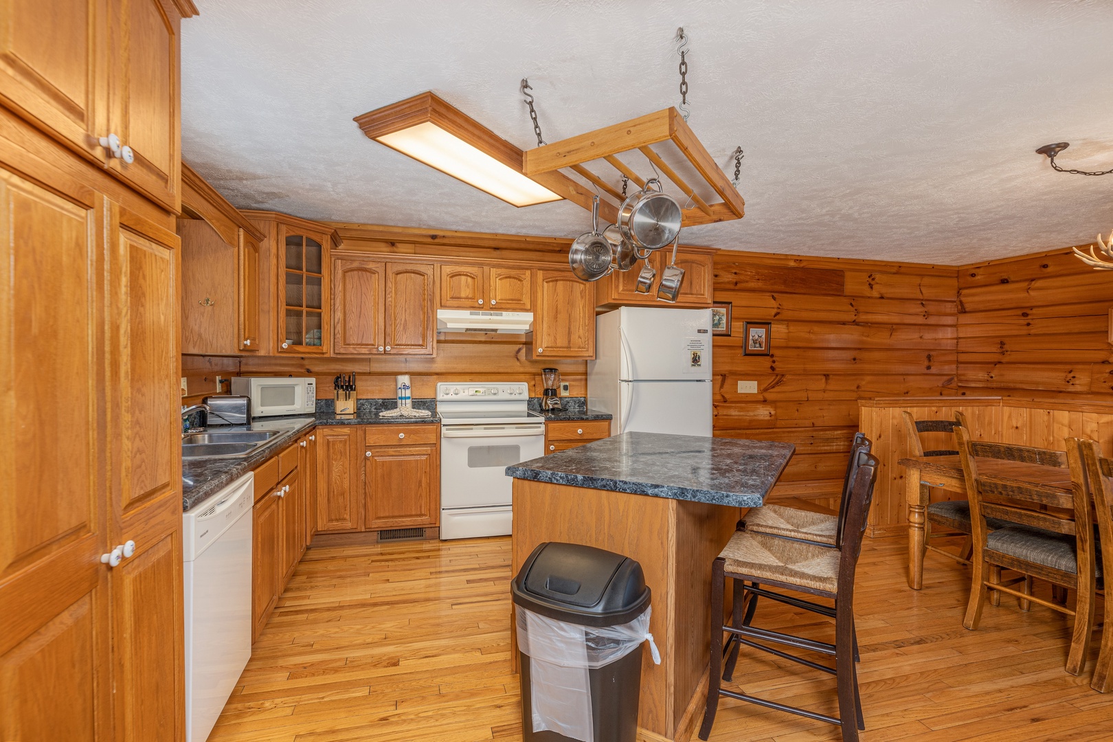 Kitchen with white appliances and a breakfast bar at Wildlife Retreat, a 3 bedroom cabin rental located in Pigeon Forge