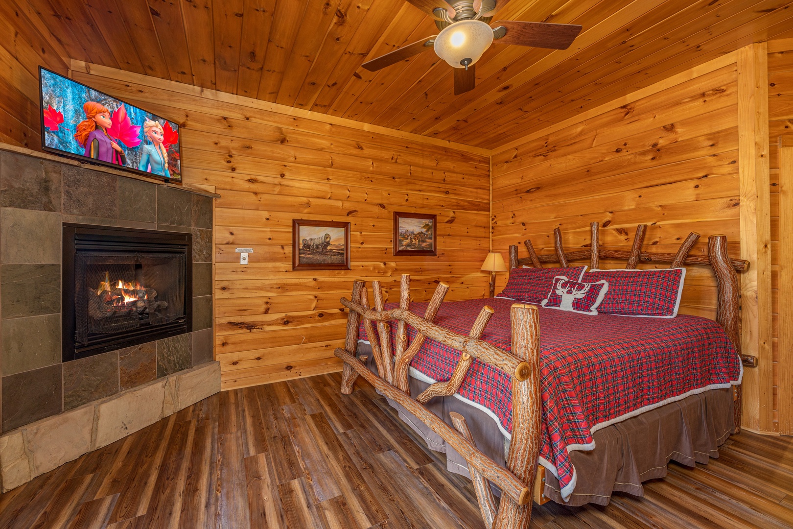 Bedroom with a king bed, fireplace, and TV at God's Country, a 4 bedroom cabin rental located in Pigeon Forge