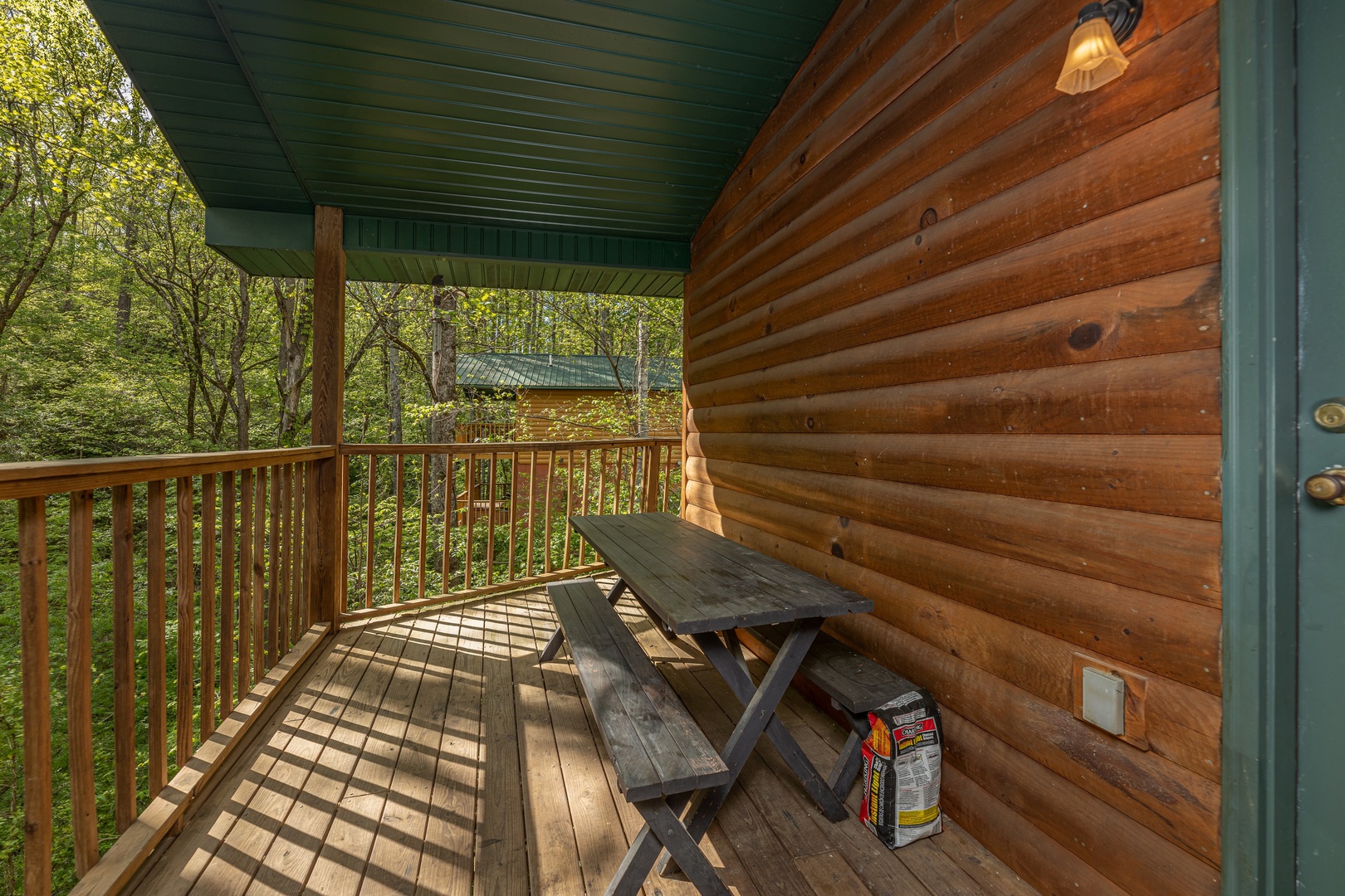 Picnic table on a covered deck at A Moment in Time, a 2 bedroom cabin rental located in Pigeon Forge