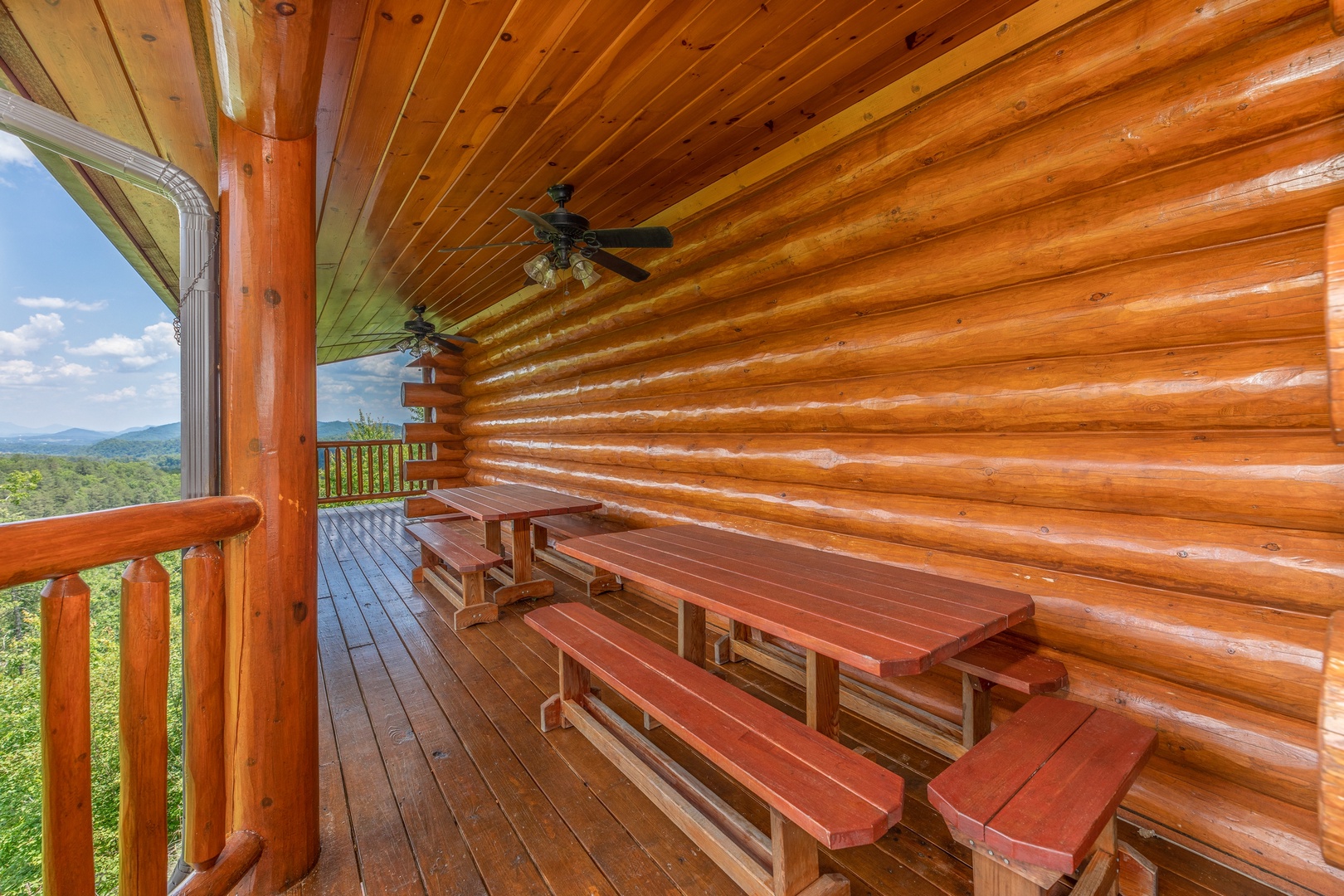 Picnic tables on a covered deck at God's Country, a 4 bedroom cabin rental located in Pigeon Forge