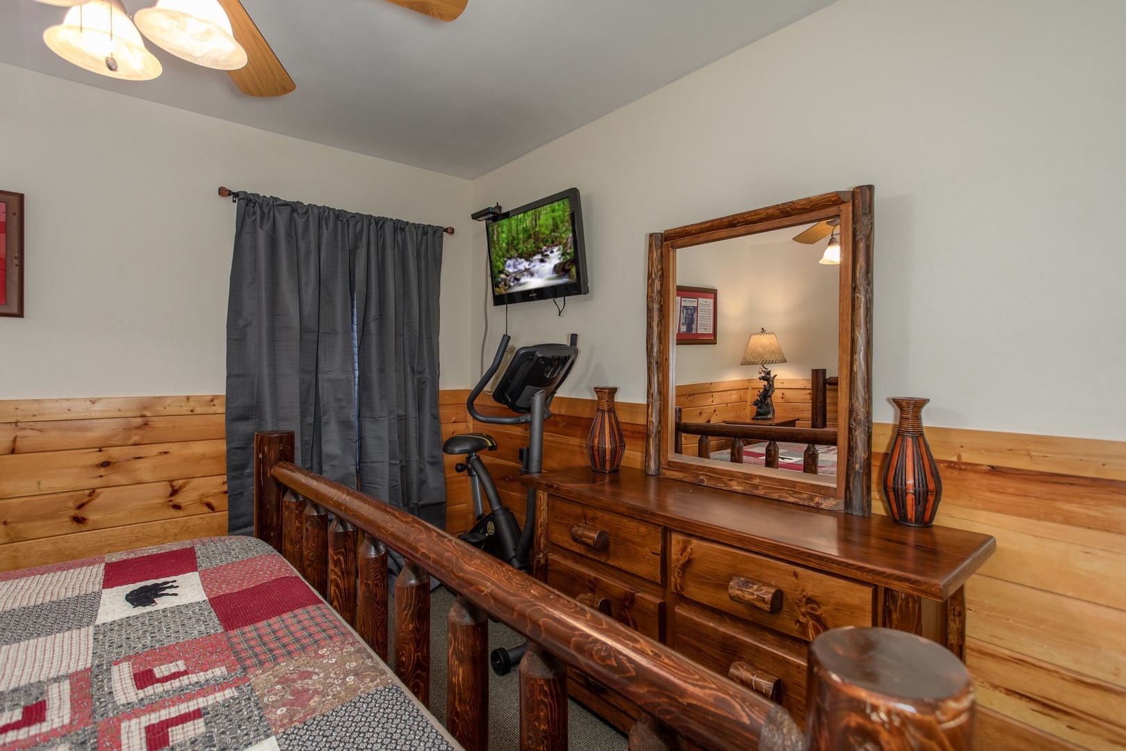 Dresser, exercise bike, and TV in a bedroom at Mountain Music, a 5 bedroom cabin rental located in Pigeon Forge