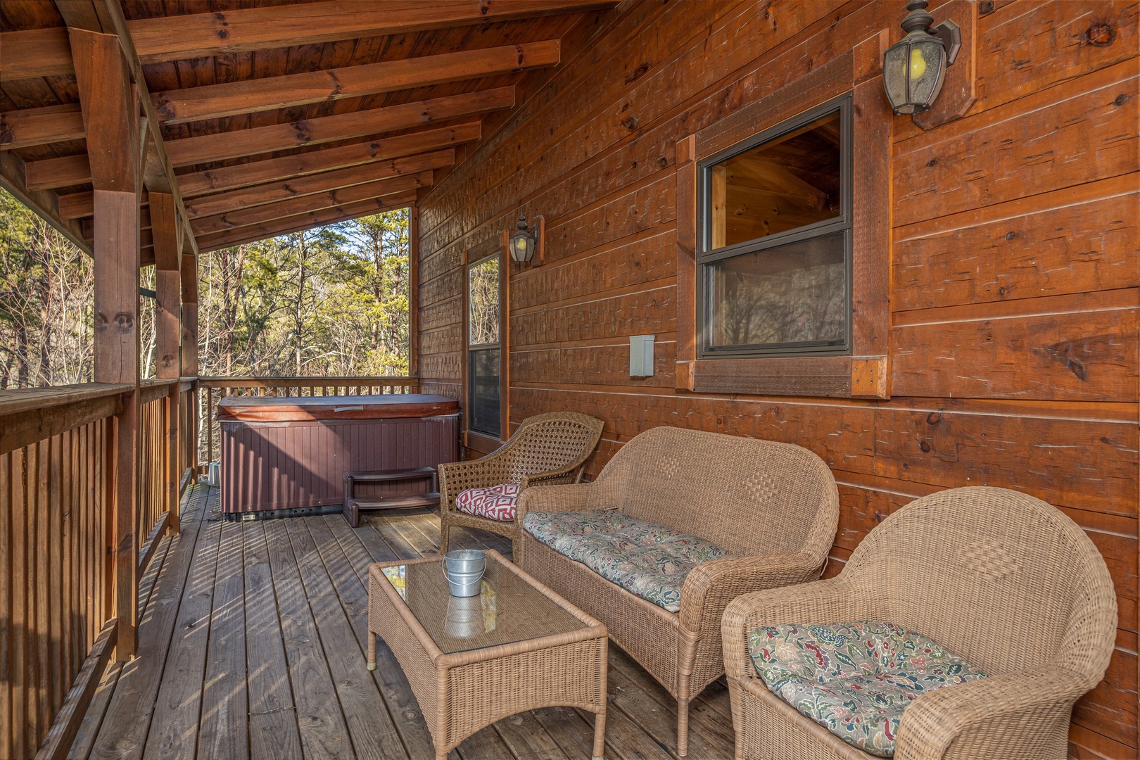 Wicker furniture on a covered deck at King of the Mountain, a 3 bedroom cabin rental located in Pigeon Forge