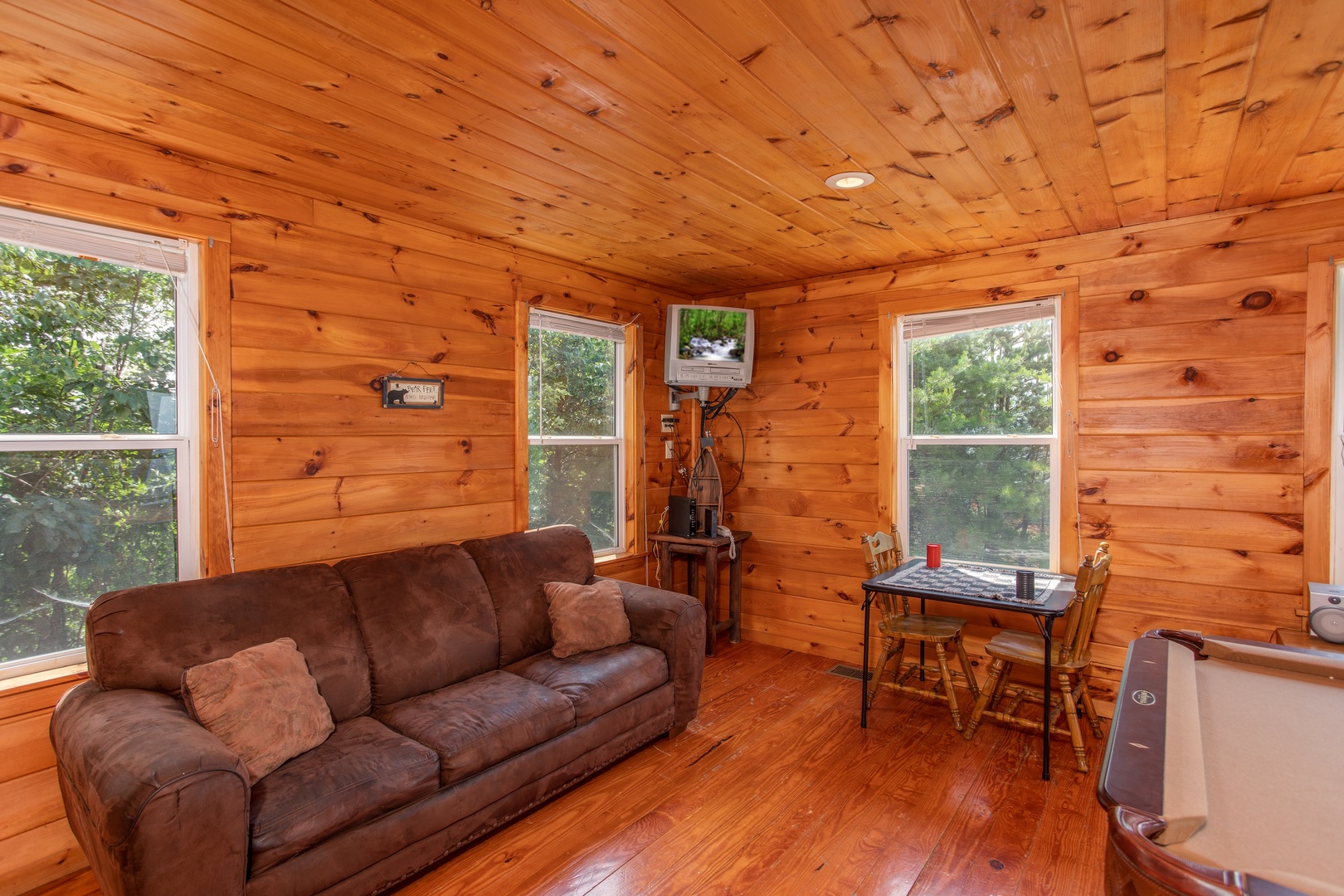 Sofa, checker table, and wall-mounted television at Black Bear Ridge, a 3-bedroom cabin rental located in Pigeon Forge