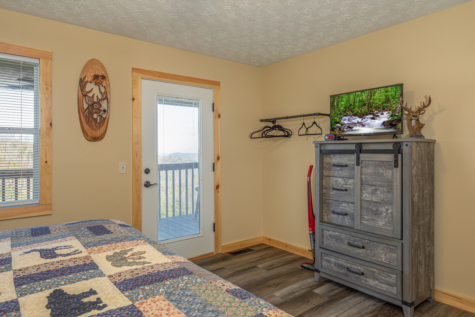 Dresser, TV, and deck access in a bedroom at Le Bear Chalet, a 7 bedroom cabin rental located in Gatlinburg