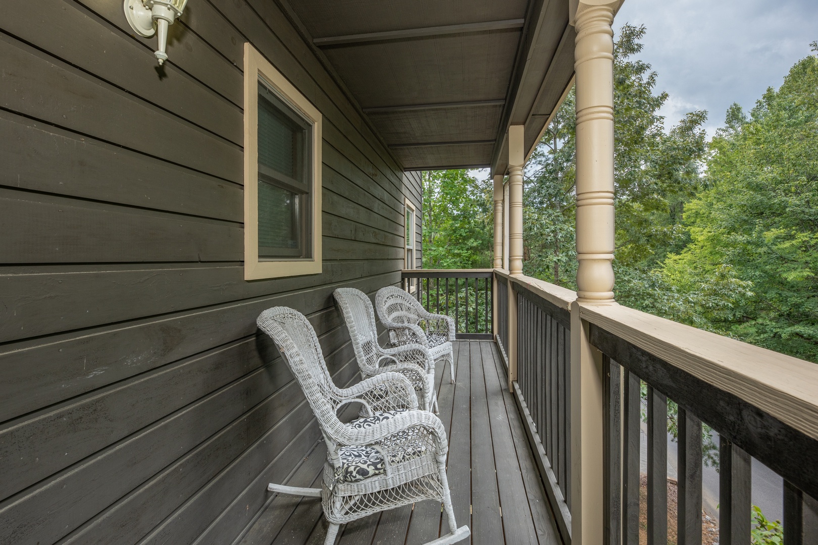 Wicker rocking chairs on a covered deck at Amazing Memories, a 3 bedroom cabin rental located in Pigeon Forge