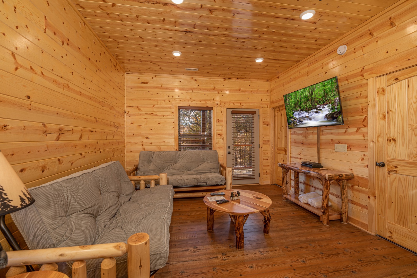 Two futons and a TV in the lower living room at Pinot Splash, a 4 bedroom cabin rental located in Gatlinburg