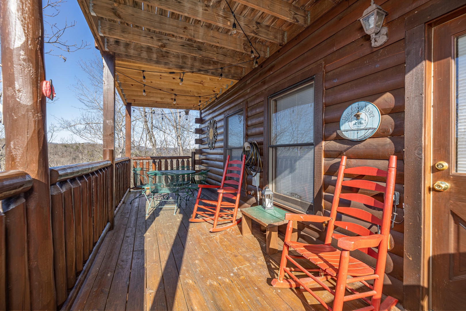 Rocking chairs on a covered deck at Nascar Nation, a 2 bedroom cabin rental located in Pigeon Forge