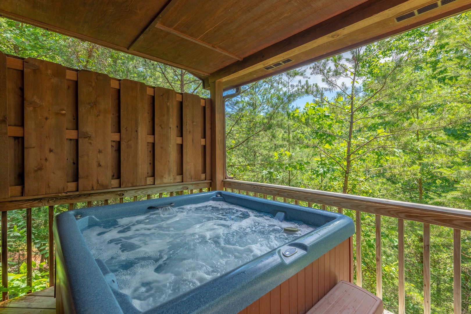 Hot tub on a covered deck at Hello Dolly, a 1 bedroom cabin rental located in Pigeon Forge