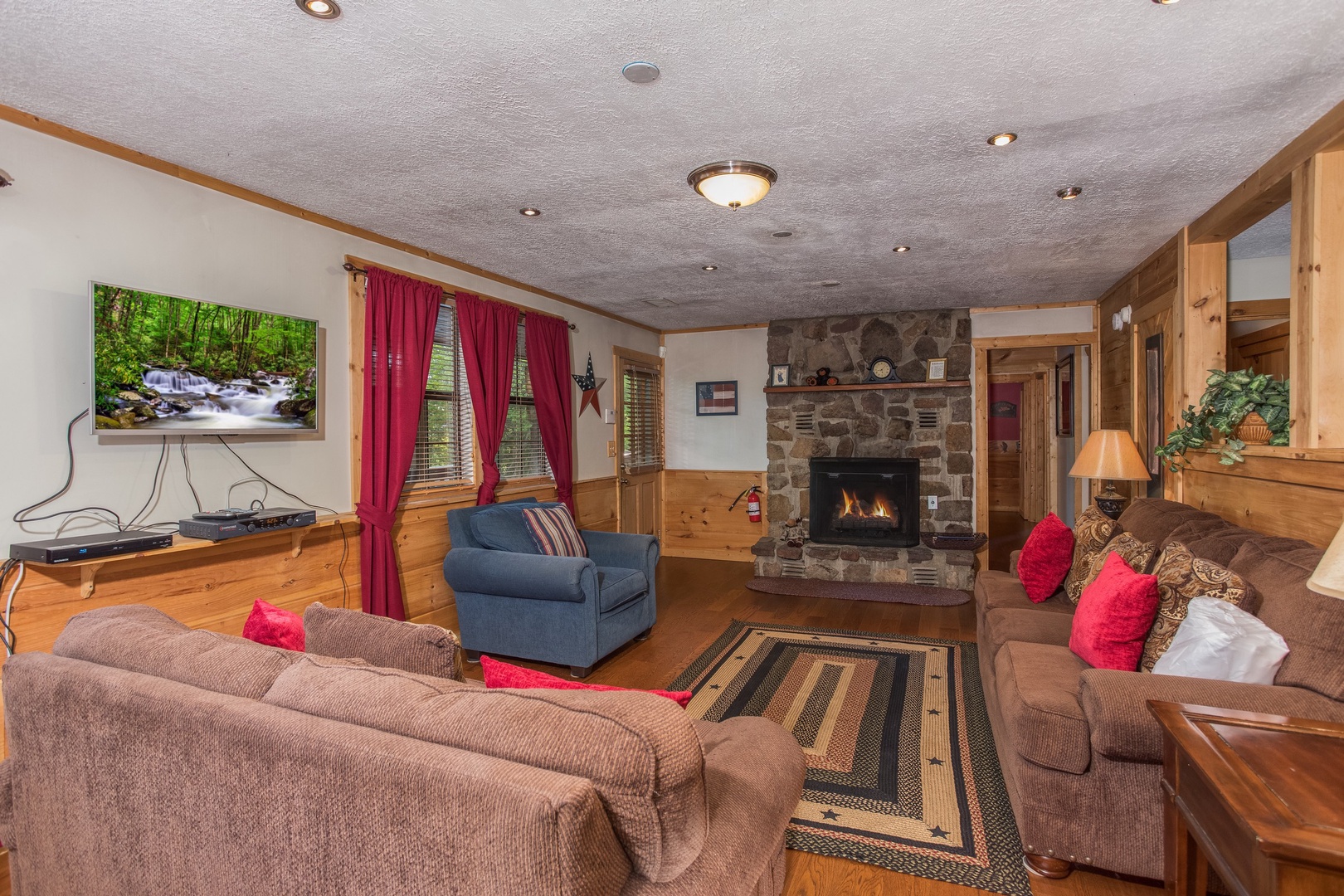 Living room with TV, fireplace, and seating at Patriot Pointe, a 5 bedroom cabin rental located in Pigeon Forge