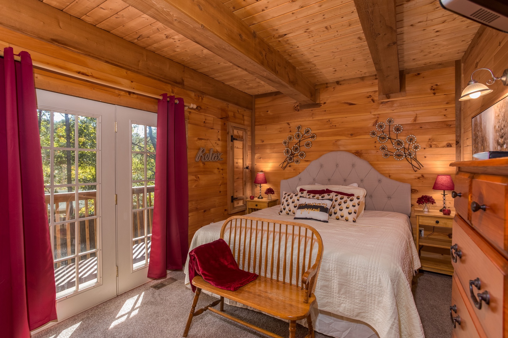 Bedroom with deck access, lamps, and night stand at Living on Love, a 2 bedroom cabin rental located in Pigeon Forge