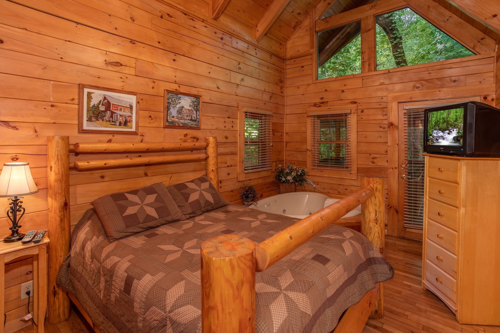 Bedroom with queen-sized log bed and a heart-shaped jacuzzi at Dreams Do Come True, a 1-bedroom cabin rental located in Pigeon Forge