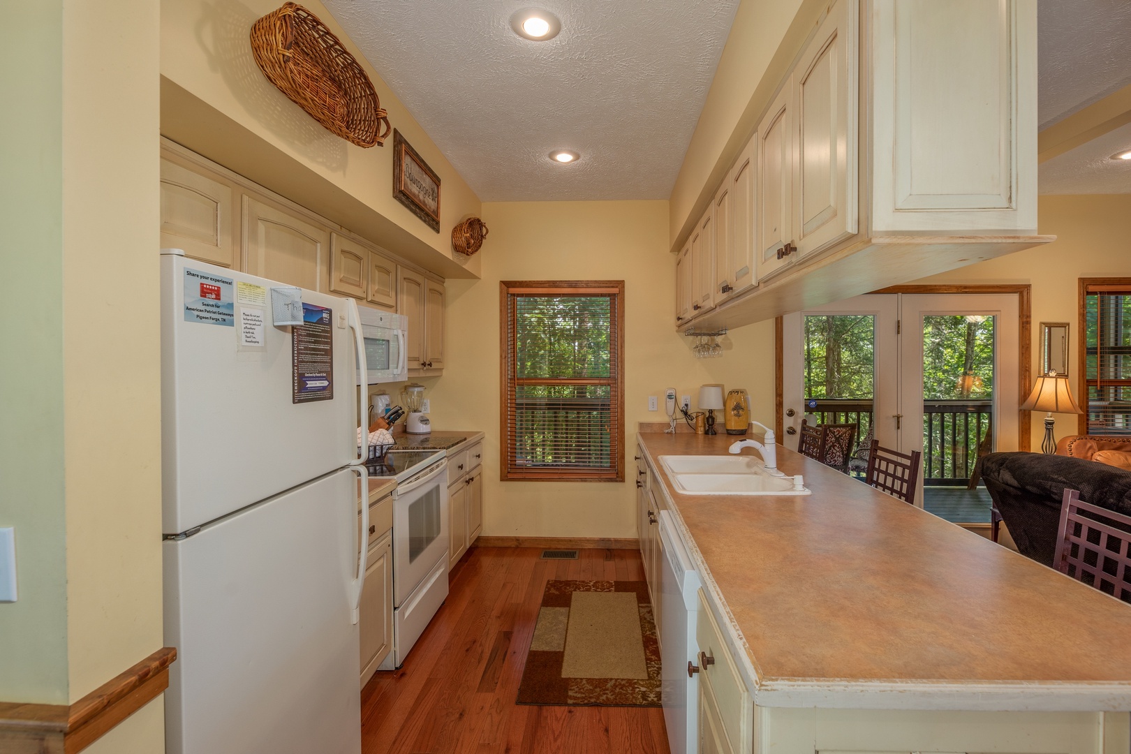 Galley kitchen with white appliances and a breakfast bar at Amazing Memories, a 3 bedroom cabin rental located in Pigeon Forge
