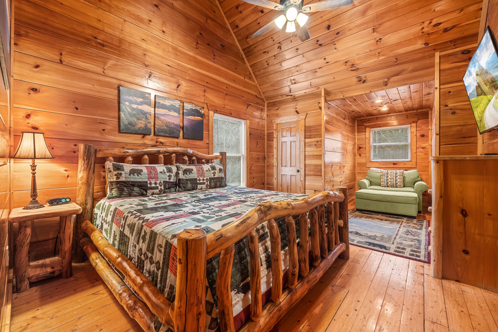 Bedroom with a log bed, night stand, lamp, and loveseat at Moonshine Memories, a 2 bedroom cabin rental located in Gatlinburg