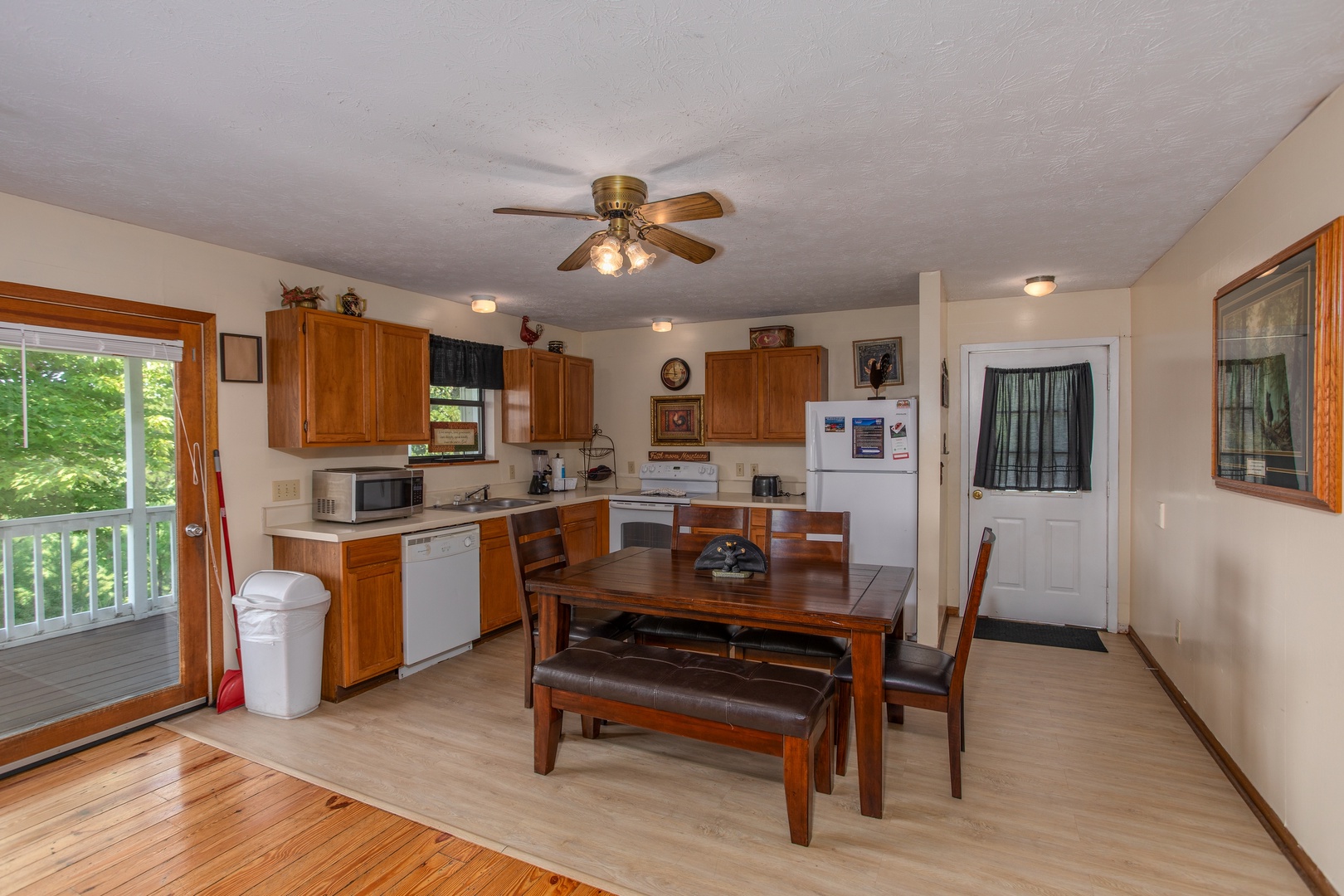 Kitchen with white appliances and dining space for six at Black Bear Ridge, a 3-bedroom cabin rental located in Pigeon Forge
