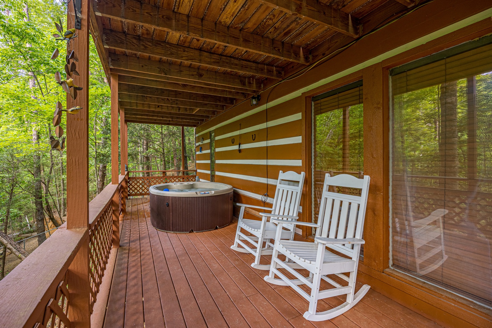 Rocking chairs and hot tub at Copper Owl, a 2 bedroom cabin rental located in Pigeon Forge