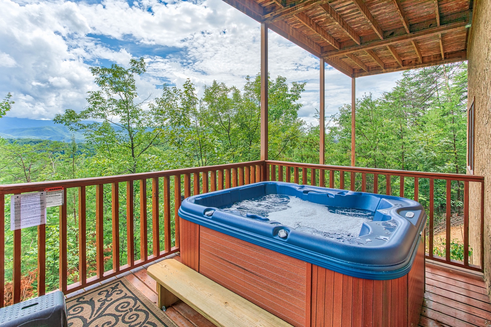 Hot tub on a covered deck at I Do Love Views, a 3 bedroom cabin rental located in Pigeon Forge