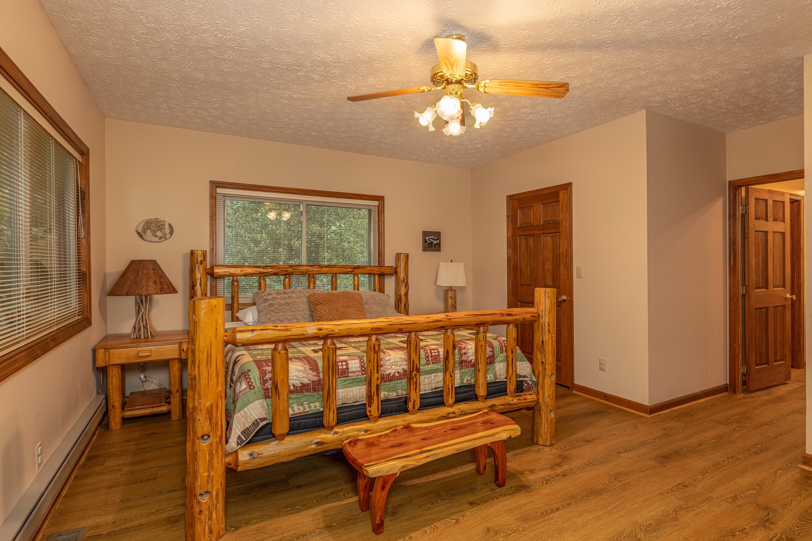 Bedroom with a log bed, two night stands, and a bench at Cubs' Crib, a 3 bedroom cabin rental located in Gatlinburg