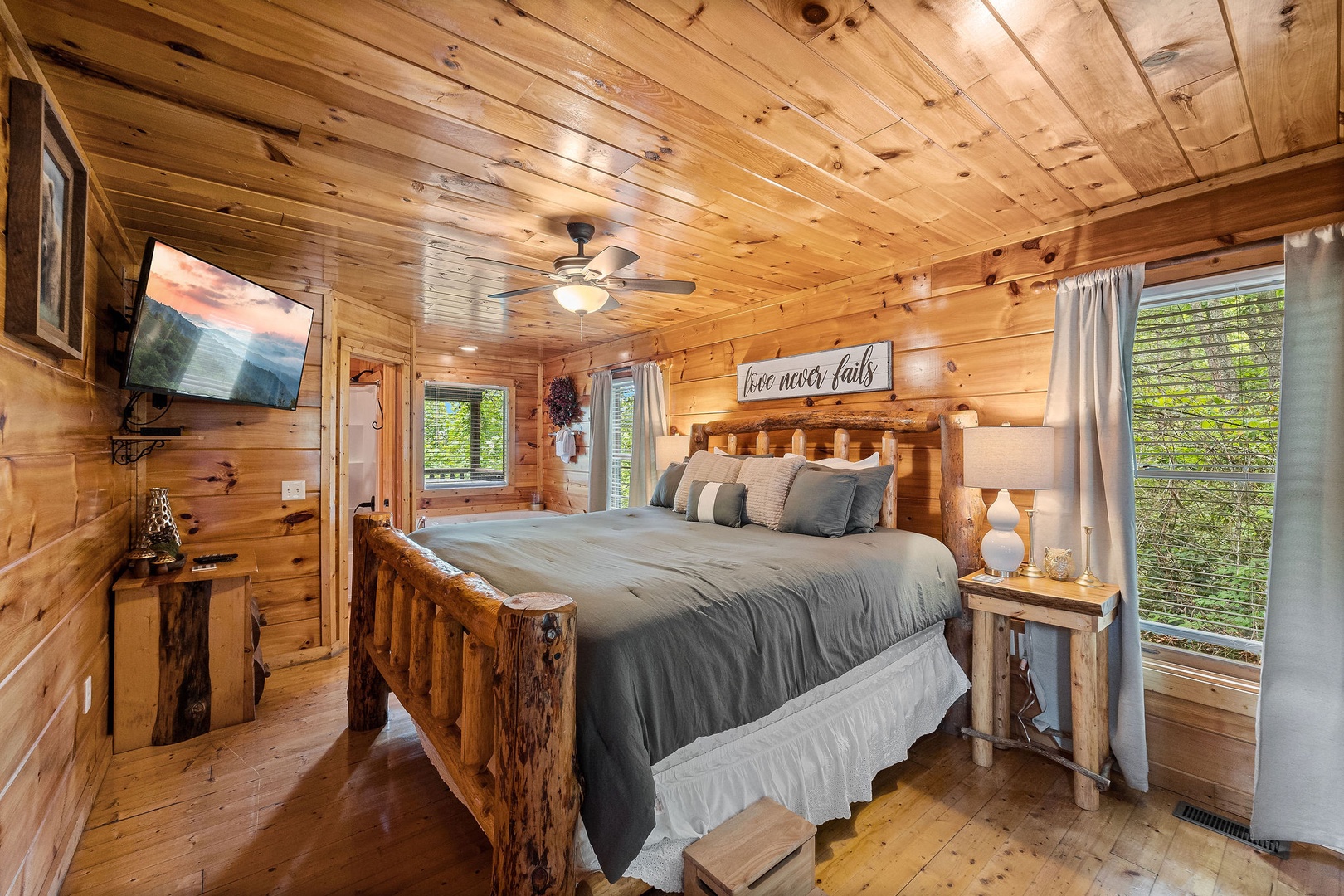 TV, jacuzzi, and bathroom at Honey Bear Haven, a 1 bedroom cabin rental located in Pigeon Forge