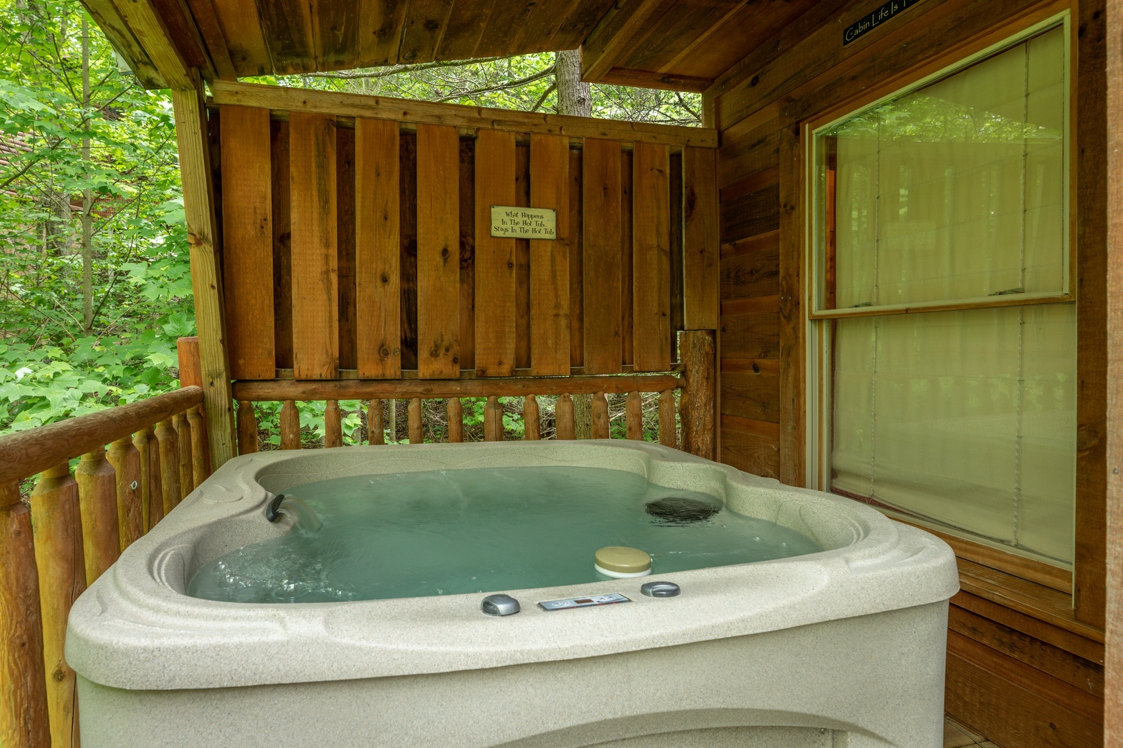 Hot tub and privacy fence on the deck at Logan's Smoky Den, a 2 bedroom cabin rental located in Pigeon Forge
