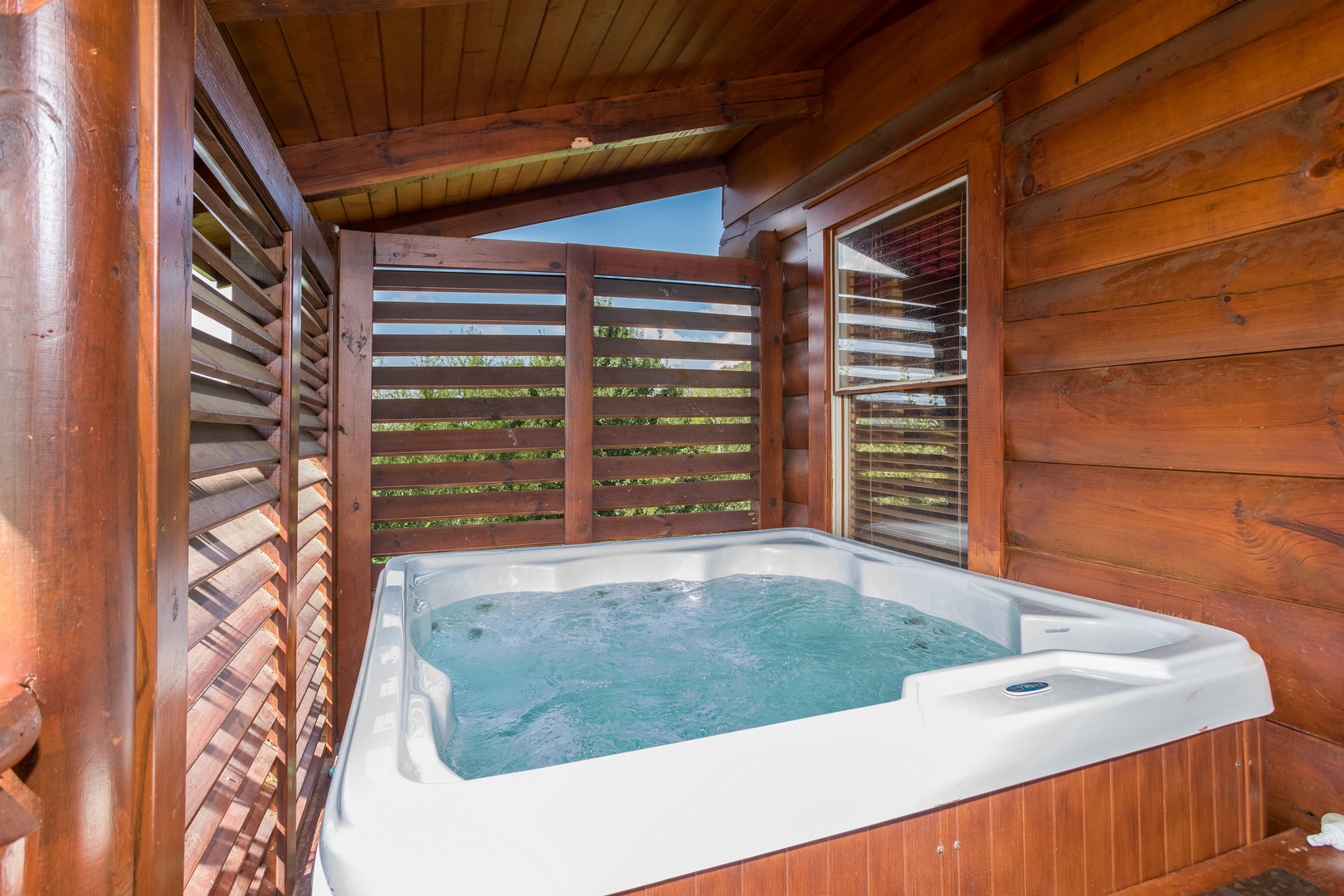 Hot tub on the covered deck at Graceland, a 4-bedroom cabin rental located in Pigeon Forge