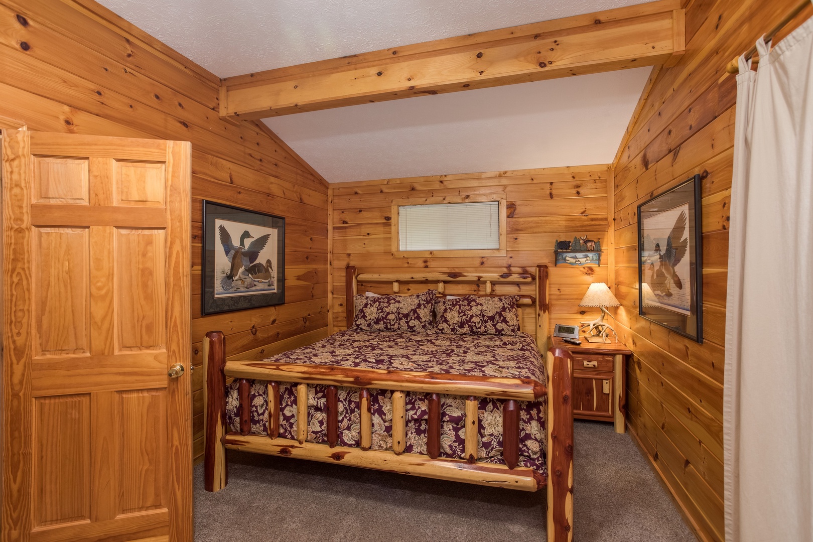 Bedroom with a log bed, night table, and lamp at Bird's Eye View, a 2-bedroom cabin rental located in Gatlinburg