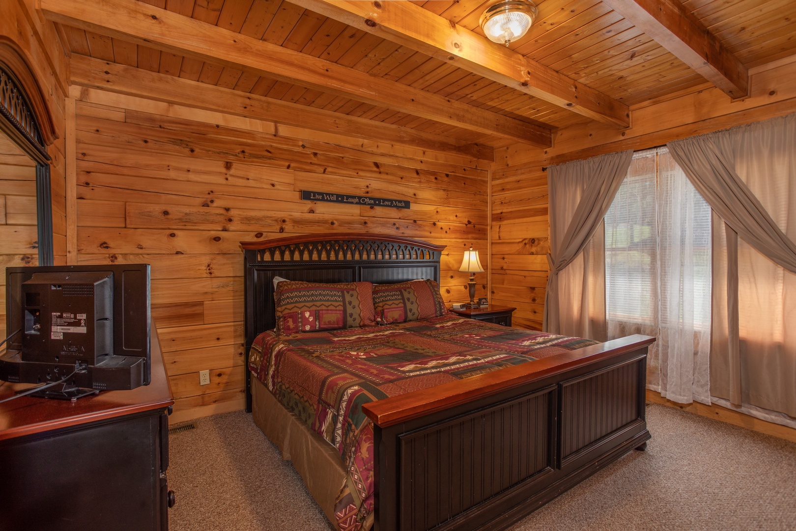Bedroom with a bed, night stand, dresser, and TV at Momma Bear, a 2 bedroom cabin rental located in Pigeon Forge