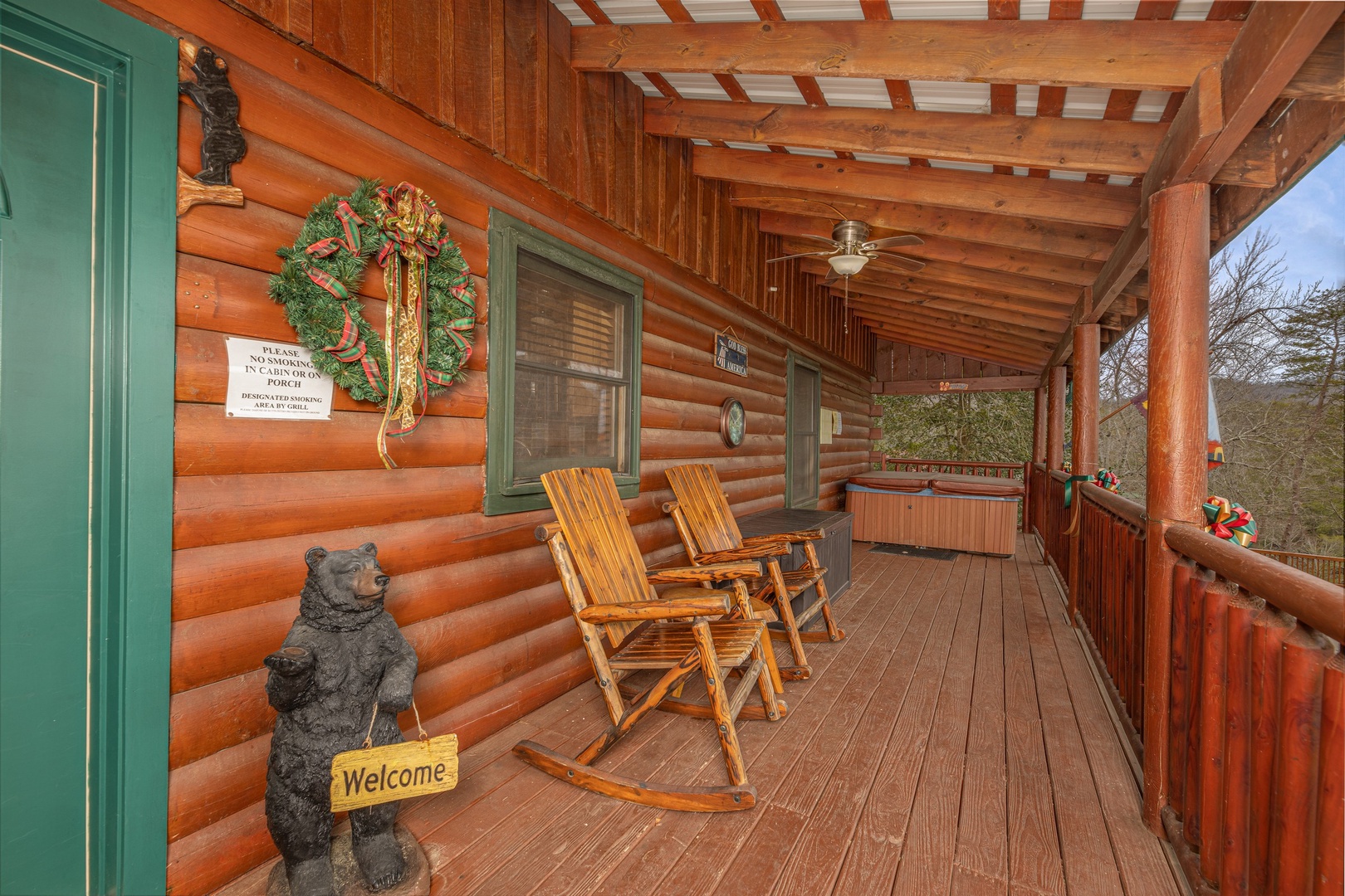 Rocking chairs and hot tub on a covered porch at Pigeon Forge Pleasures, a 3 bedroom cabin rental located in Pigeon Forge