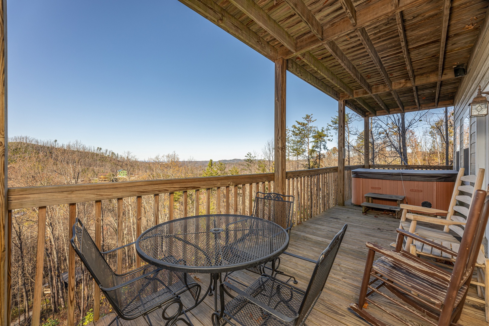 Table for three and hot tub on the deck at Le Bear Chalet, a 7 bedroom cabin rental located in Gatlinburg