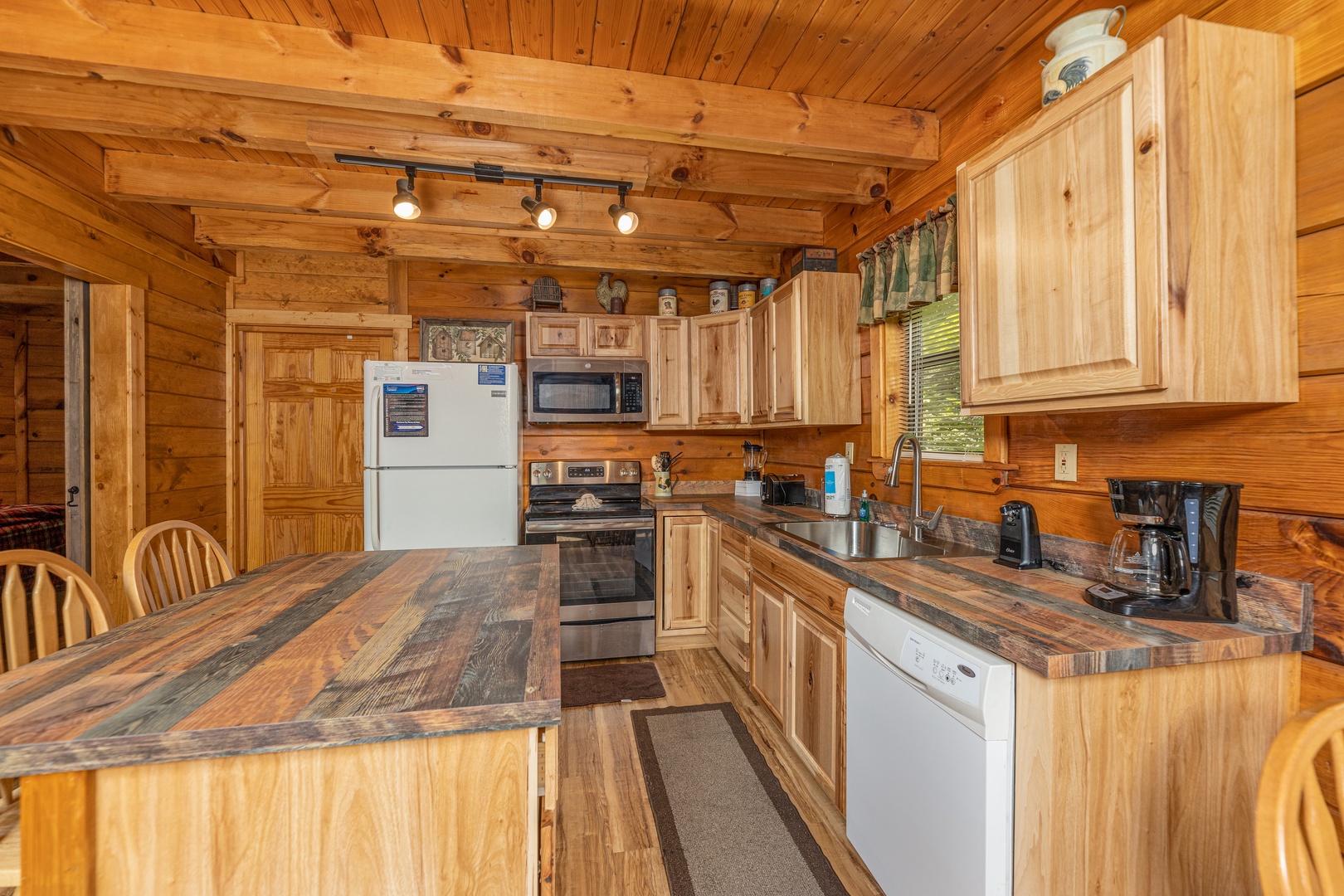 Kitchen with white and stainless appliances at Honeymoon in Gatlinburg, a 1 bedroom cabin rental located in Gatlinburg