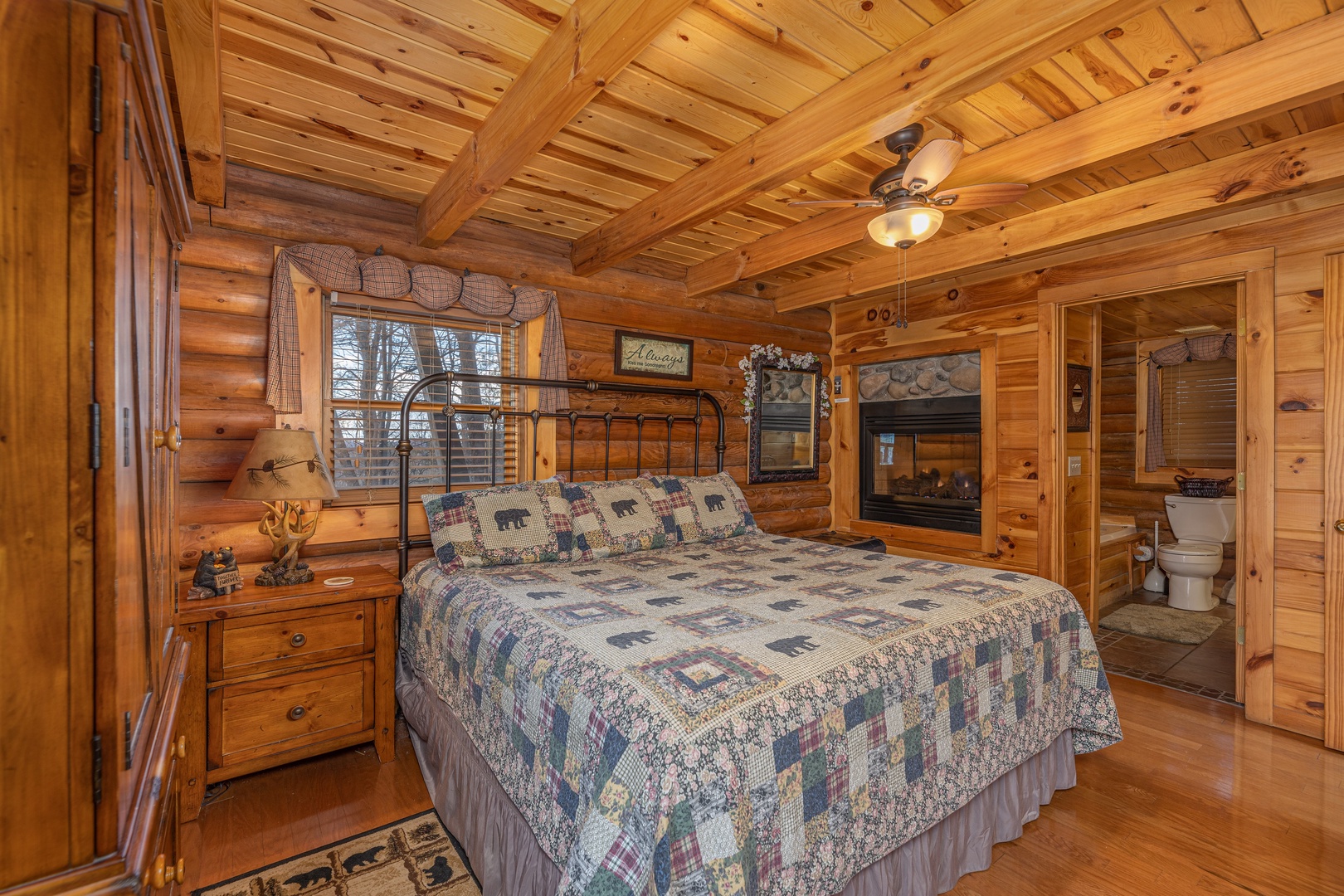 Bedroom with a double-sided fireplace at A Lover's Secret, a 1 bedroom cabin rental located in Gatlinburg