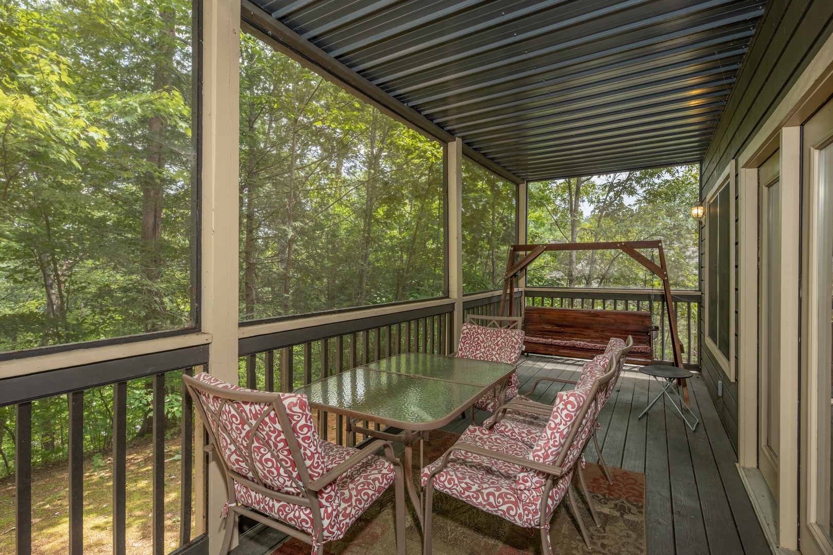 Deck dining and porch swing on a covered deck at Amazing Memories, a 3 bedroom cabin rental located in Pigeon Forge