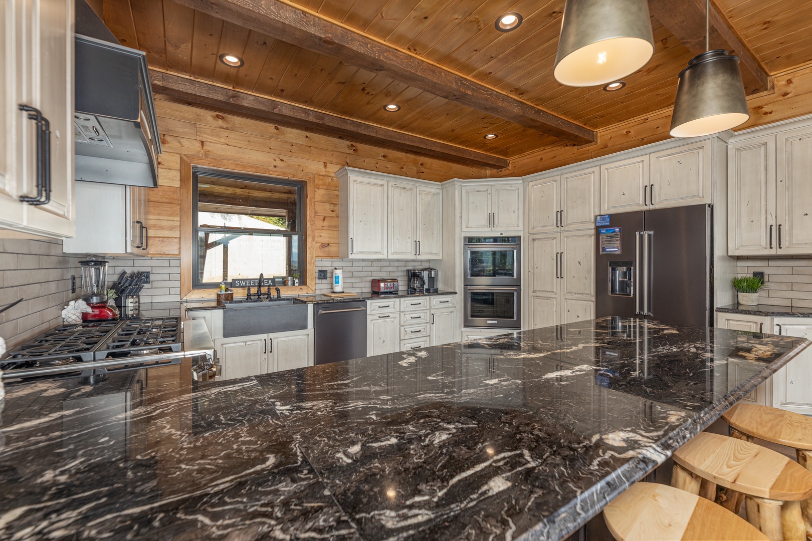 Granite counters, white cabinets, and stainless appliances in the kitchen at Black Bears & Biscuits Lodge, a 6 bedroom cabin rental located in Pigeon Forge
