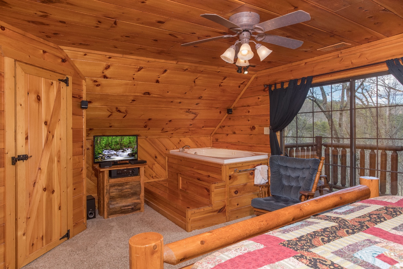 Bedroom with private deck access, in room jacuzzi, and TV at Hidden Pleasure, a 1-bedroom cabin rental located in Gatlinburg