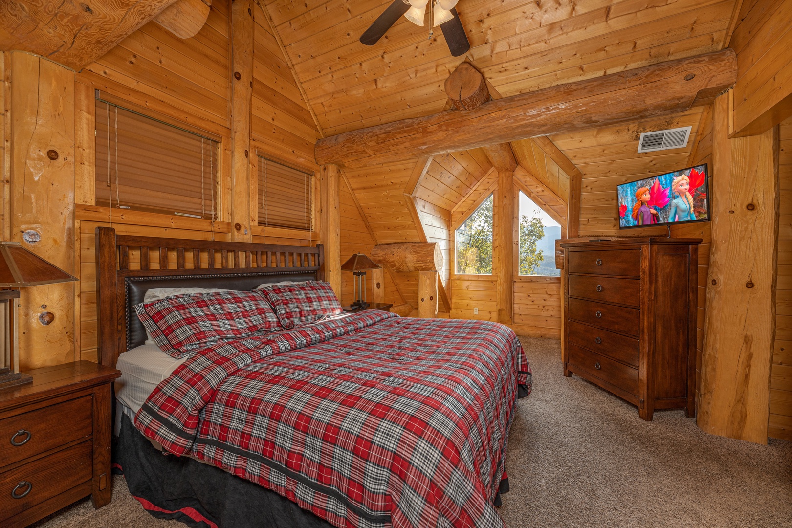 King bed, night stands, dresser, and TV in a bedroom at Grizzly's Den, a 5 bedroom cabin rental located in Gatlinburg