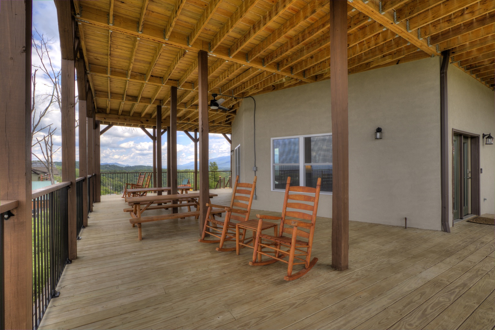 Rocking chairs and picnic table on covered deck at The Best View Lodge, a 5 bedroom cabin rental located in gatlinburg