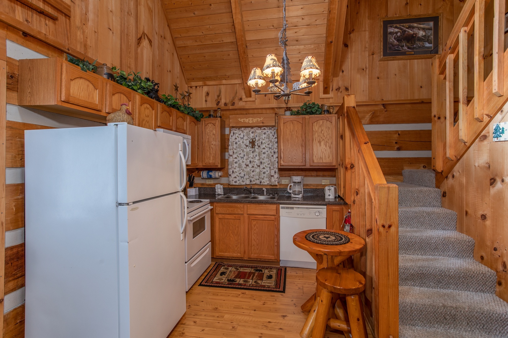 Kitchen with white appliances at Bearfoot Crossing, a 1-bedroom cabin rental located in Pigeon Forge