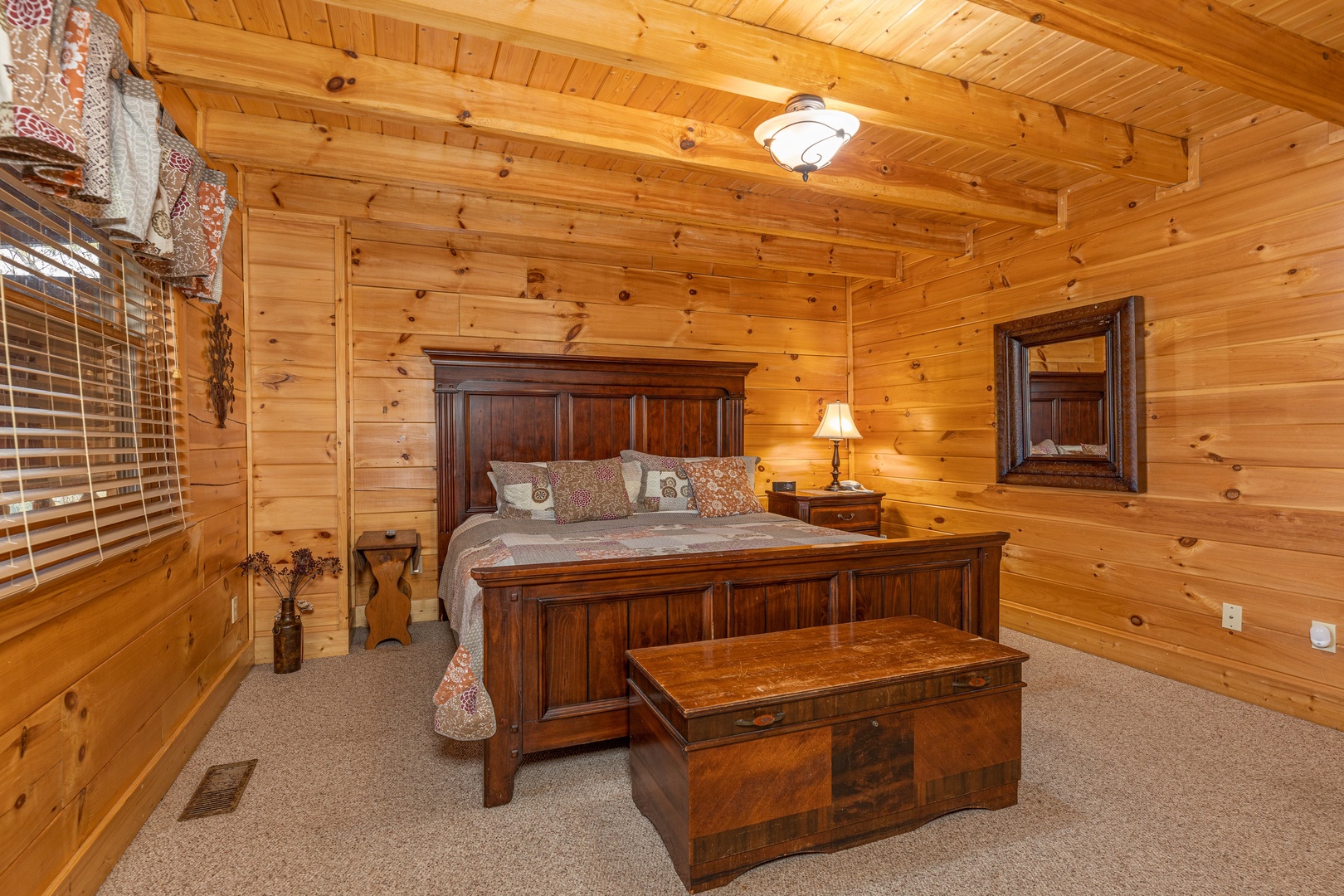 Bedroom with night stand, lamp, and chest at Absolutely Wonderful, a 2 bedroom cabin rental located in Pigeon Forge