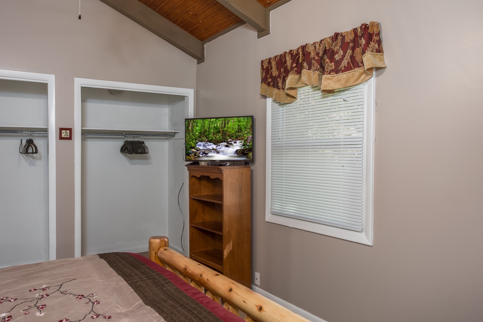 Cabinet, TV, and closets in a bedroom at Forever Country, a 3 bedroom cabin rental located in Pigeon Forge