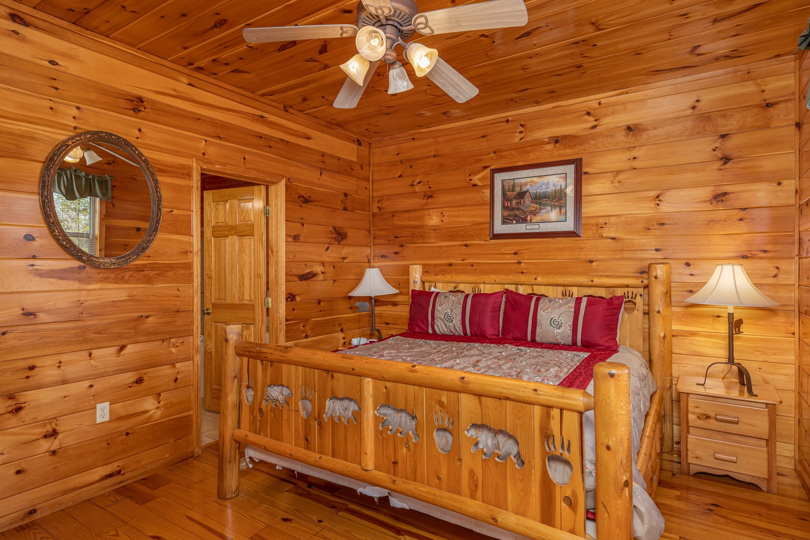 Bedroom with king bed, two night stands, and two lamps at Hickernut Lodge, a 5-bedroom cabin rental located in Pigeon Forge
