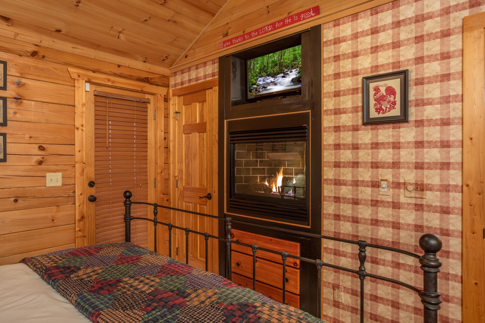 Fireplace and TV in the bedroom at Fowl Play, a 1 bedroom cabin rental located in Pigeon Forge