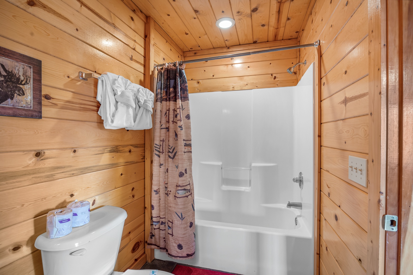 Bathroom with tub and shower combo with log bed at Natural Wonder, a 4 bedroom cabin rental located in Gatlinburg