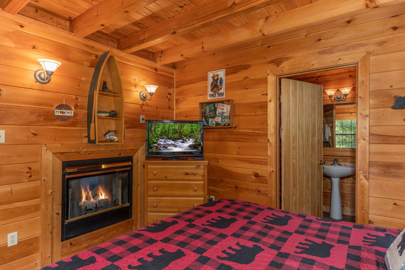 Fireplace, TV, and a dresser in the bedroom at Away From it All, a 1 bedroom cabin rental located in Pigeon Forge