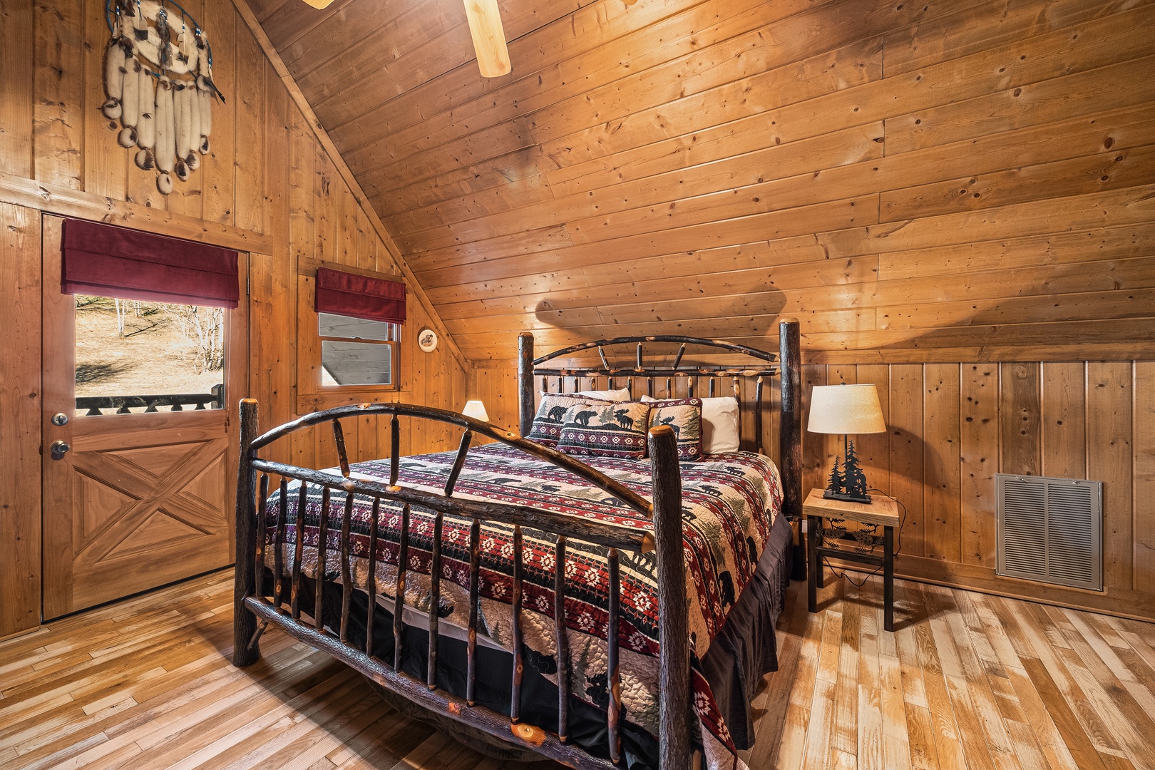 Bedroom with a wooden bed, end tables, and lamps at A Beary Nice Cabin, a 2 bedroom cabin rental located in Pigeon Forge