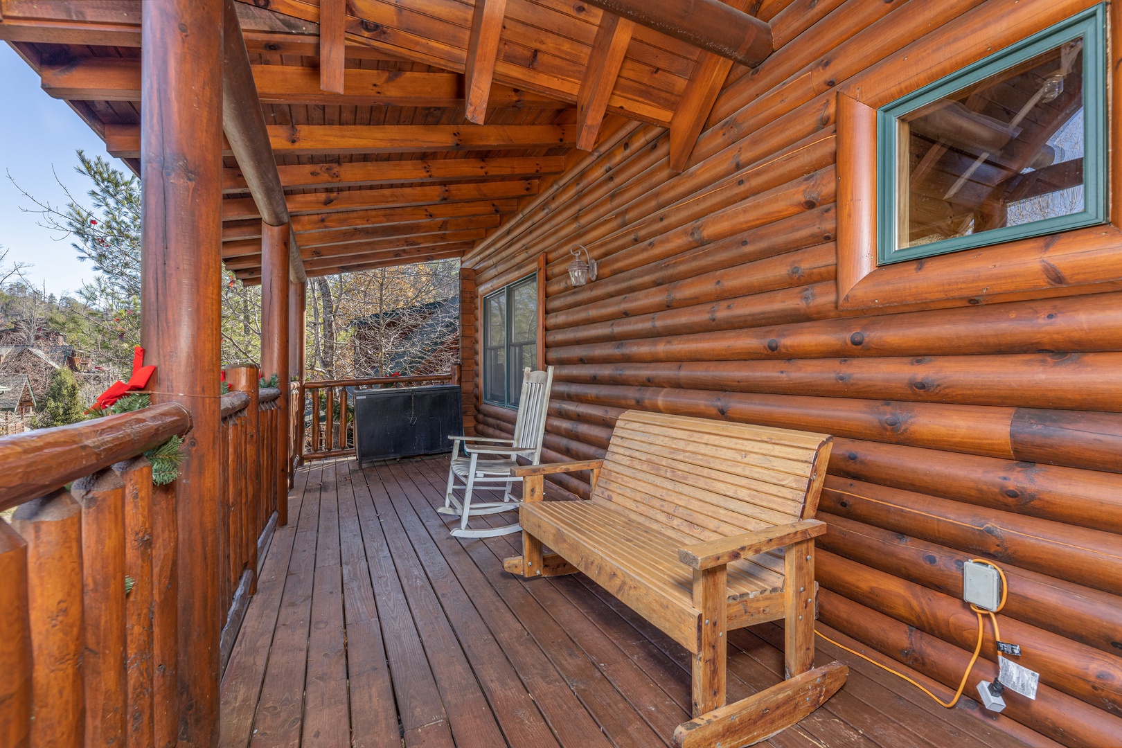 Rocking bench and rocking chair on a covered porch at Loving Every Minute, a 5 bedroom cabin rental located in Pigeon Forge