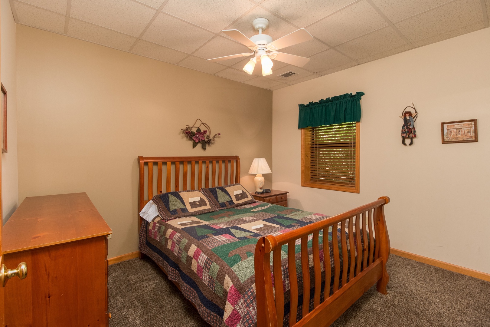 Bedroom with a bed, dresser, and night stand at Stones Throw, a 4 bedroom cabin rental located in Pigeon Forge
