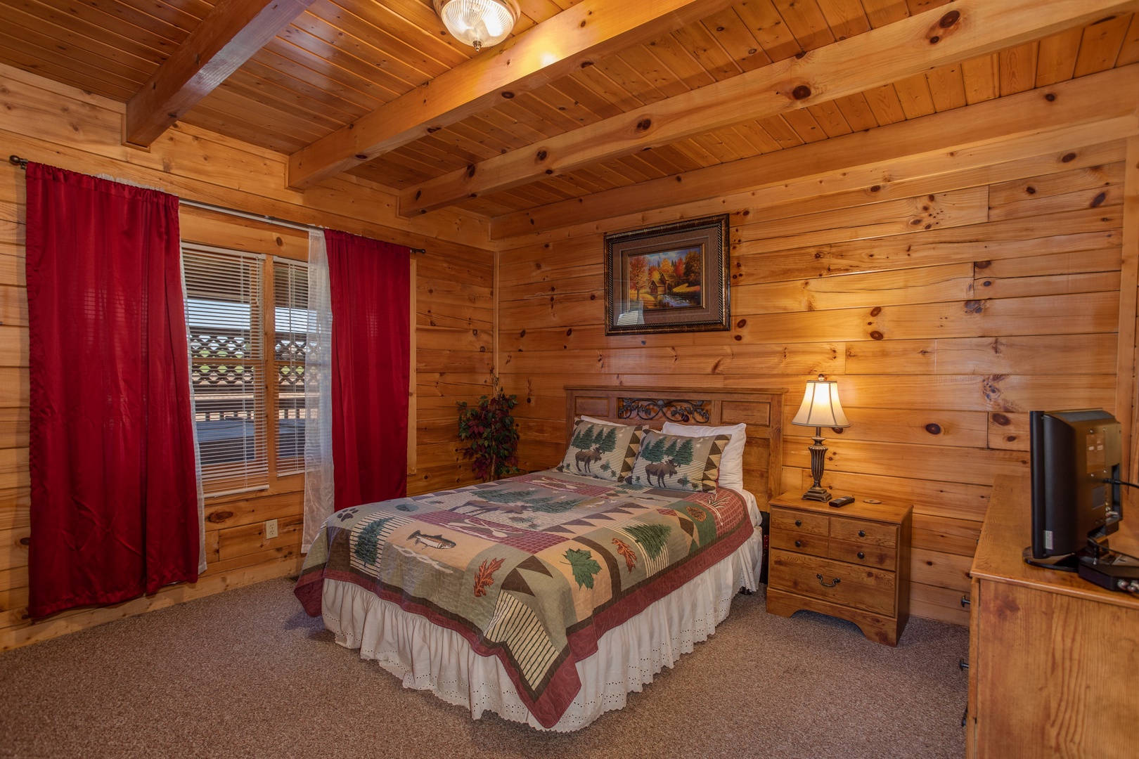 Bedroom with a bed, night stand, and lamp at Momma Bear, a 2 bedroom cabin rental located in Pigeon Forge