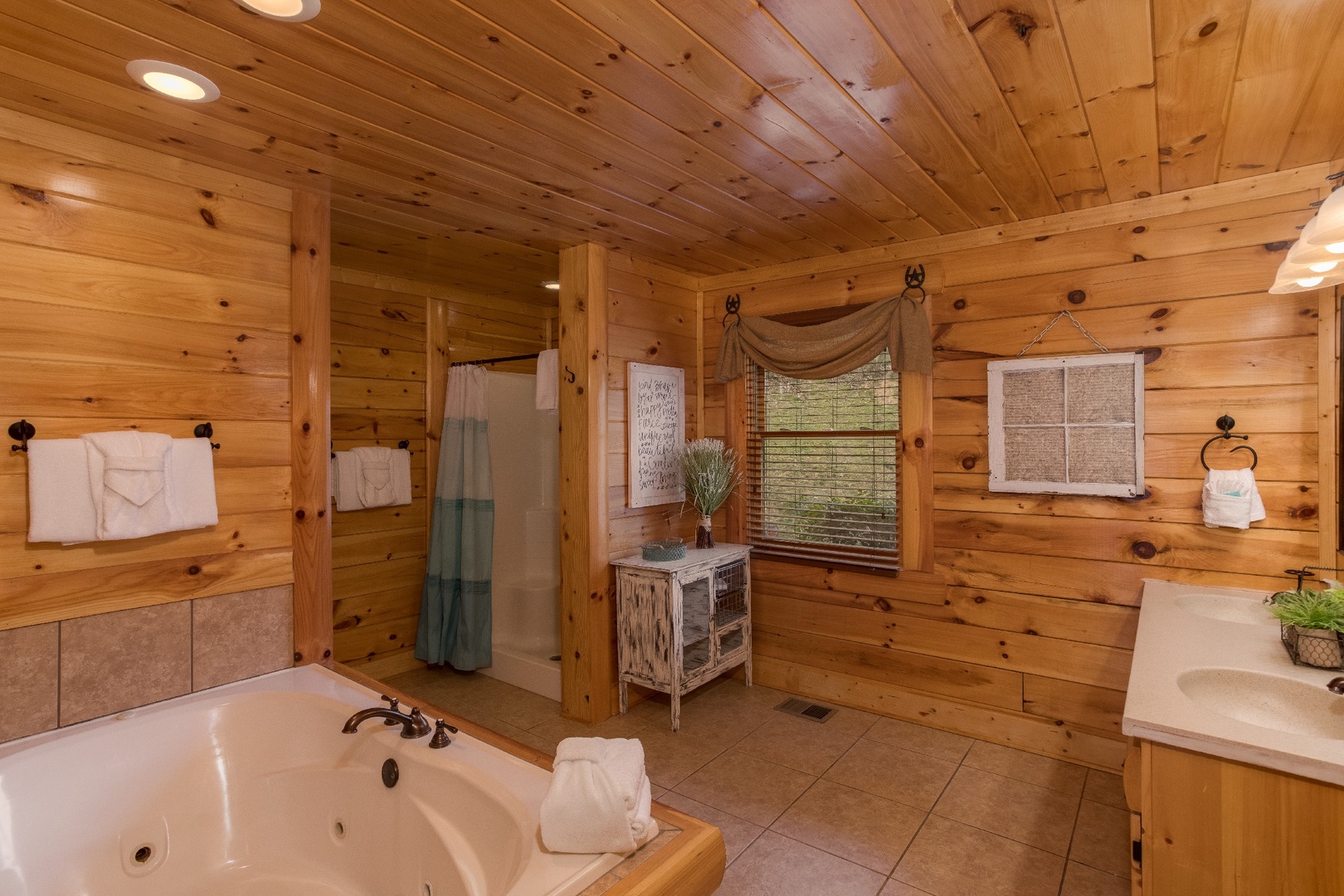 Bathroom with jacuzzi, walk in shower, and his and hers sinks at Mountain View Meadows, a 3 bedroom cabin rental located in Pigeon Forge