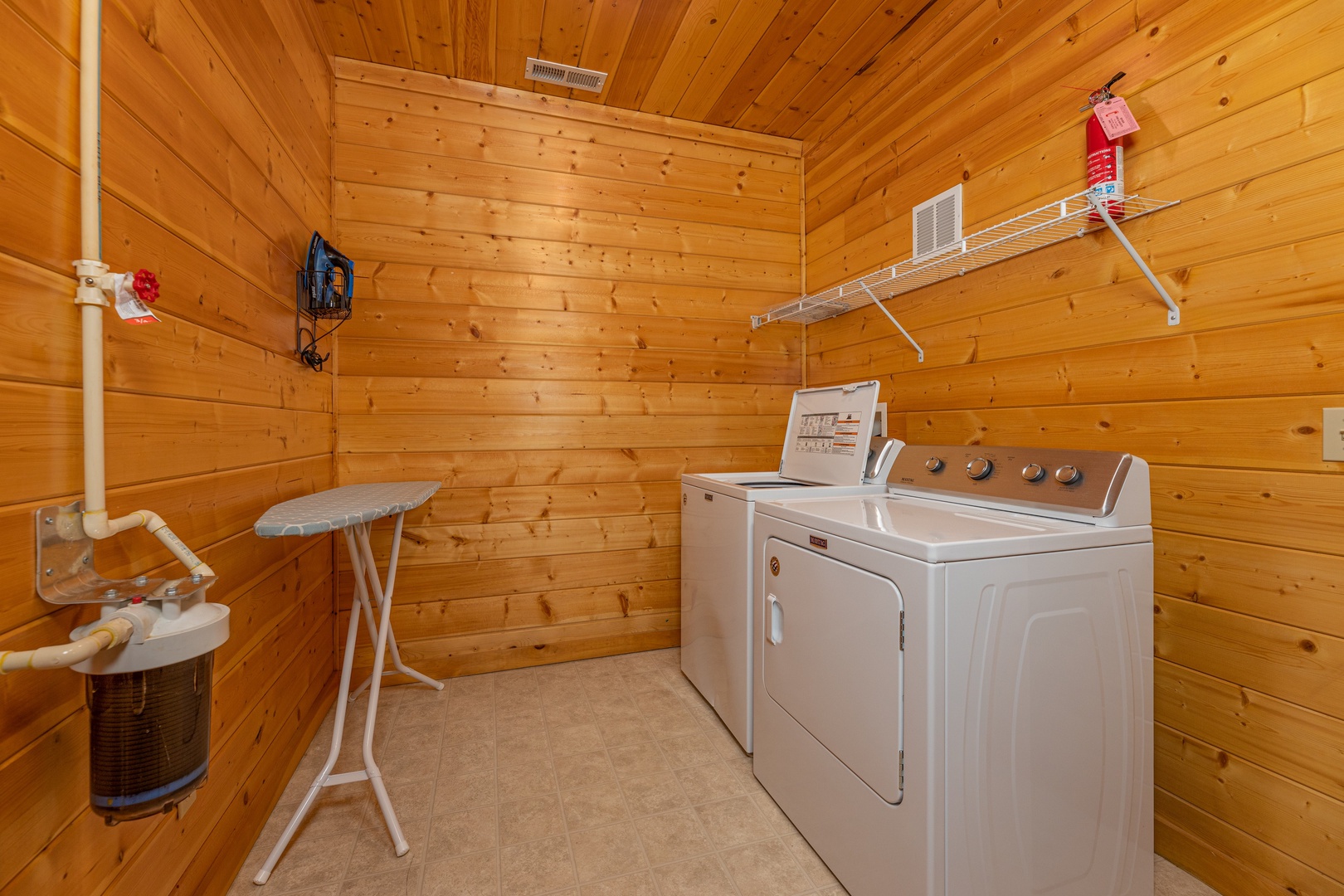Laundry room with washer, dryer, and ironing board at Grizzly's Den, a 5 bedroom cabin rental located in Gatlinburg